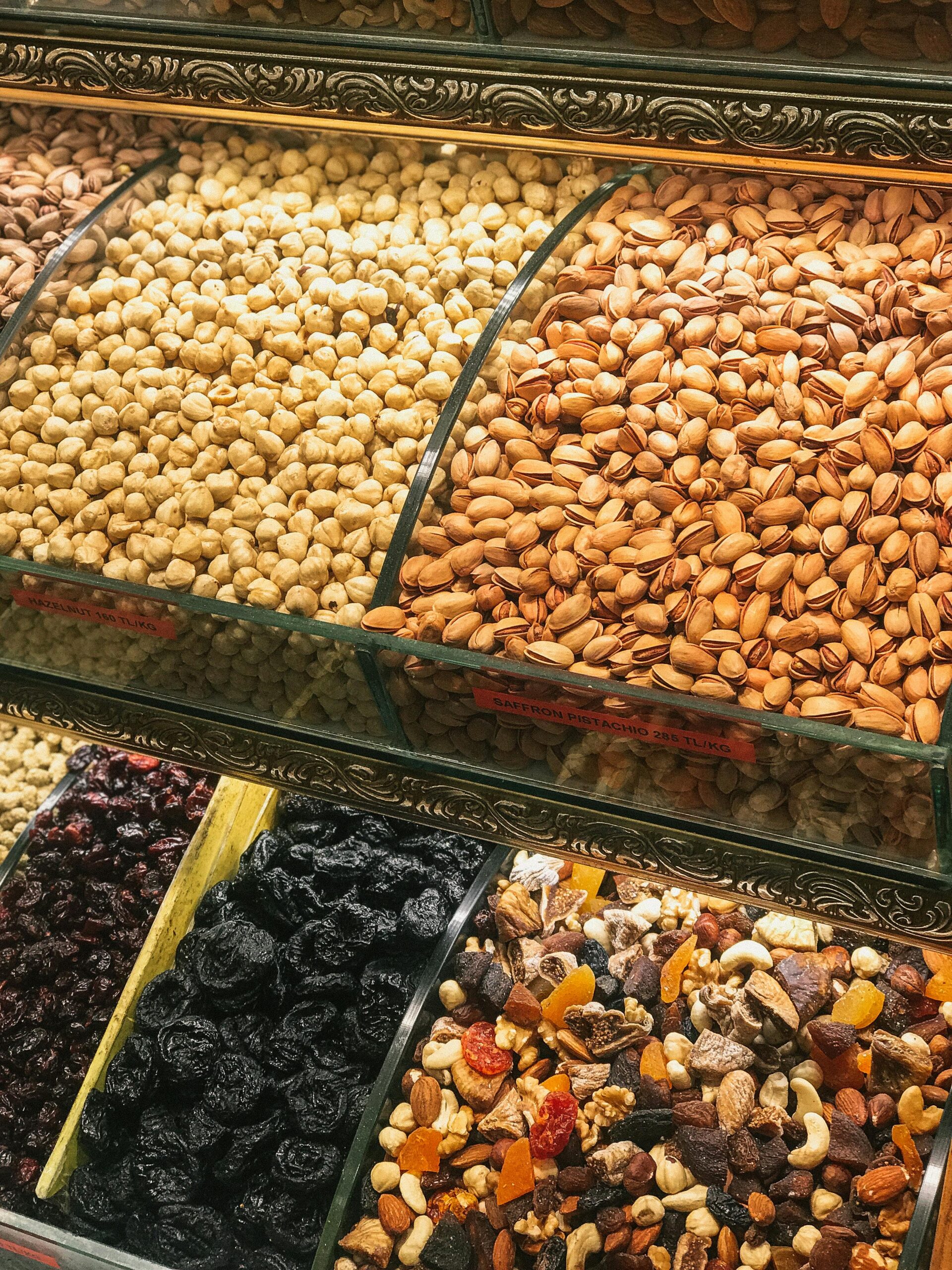 Colorful assortment of nuts and dried fruits in a market display, showcasing healthy snack options.